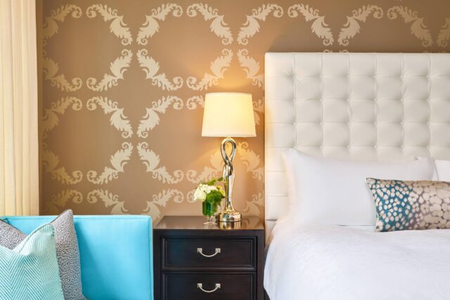 a lamp on a set of drawers between a couch and a bed