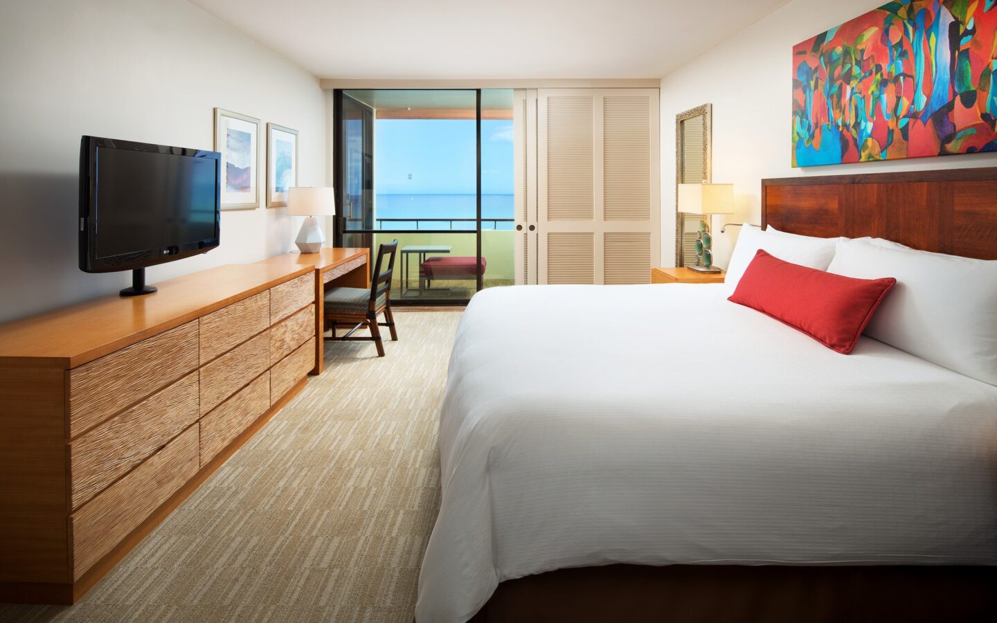hotel suite with king bed and an ocean view balcony