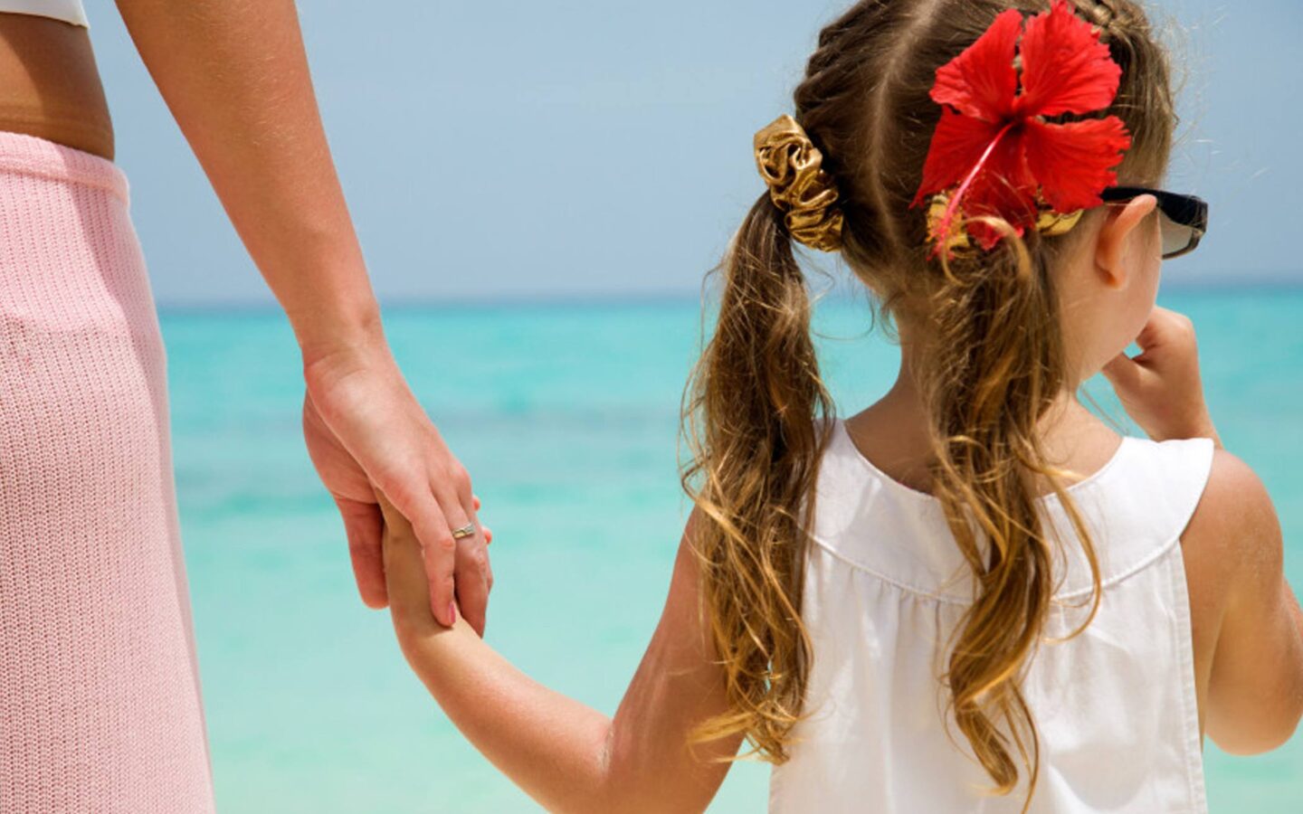 girl wearing white shirt walking on seashore
