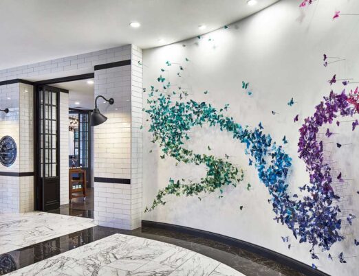 bright hotel lobby with a large art piece of butterflies covering a white wall