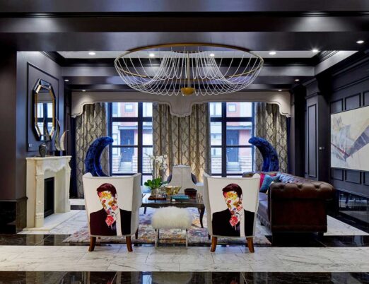 dark hotel lobby with gold accents, a white fireplace, large mirror, and large gold chandelier