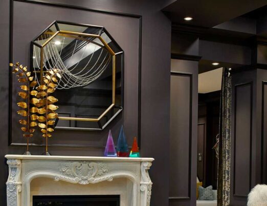 dark hotel lobby with gold accents, a white fireplace, large mirror, and large gold chandelier
