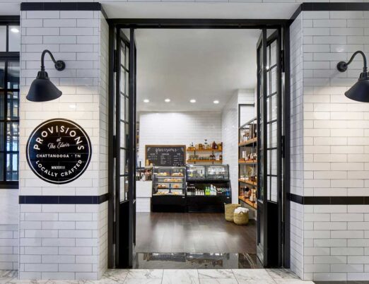 white brick entrance to a snack shop with black doors
