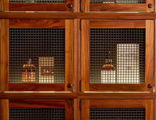 wooden display case with bottles of alcohol inside
