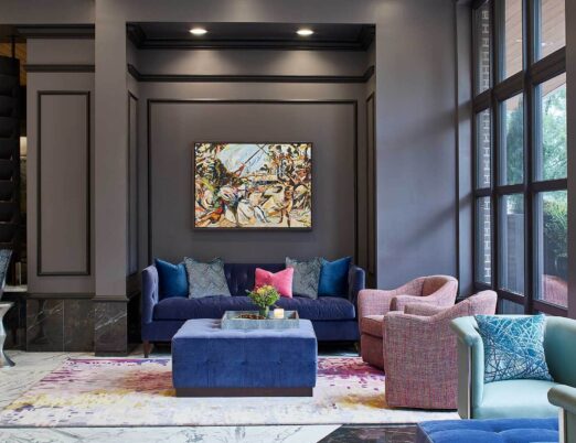 Luxury hotel lobby with large windows and plush red and purple furniture