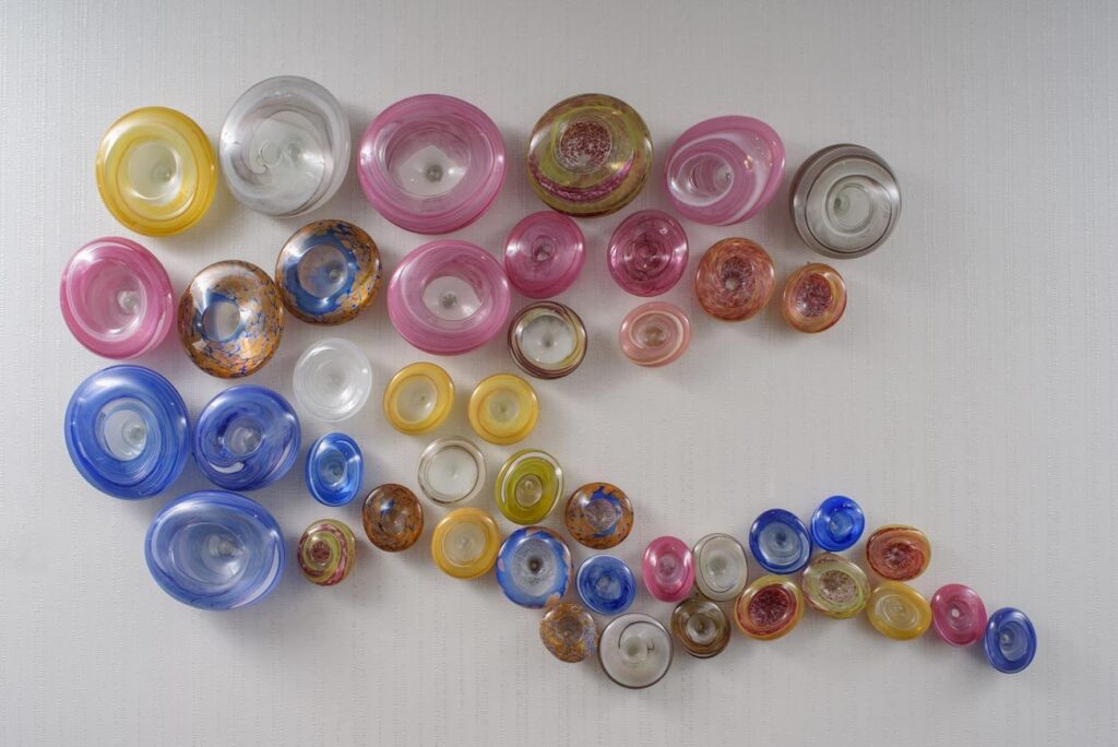 blown glass artwork displayed on a white wall