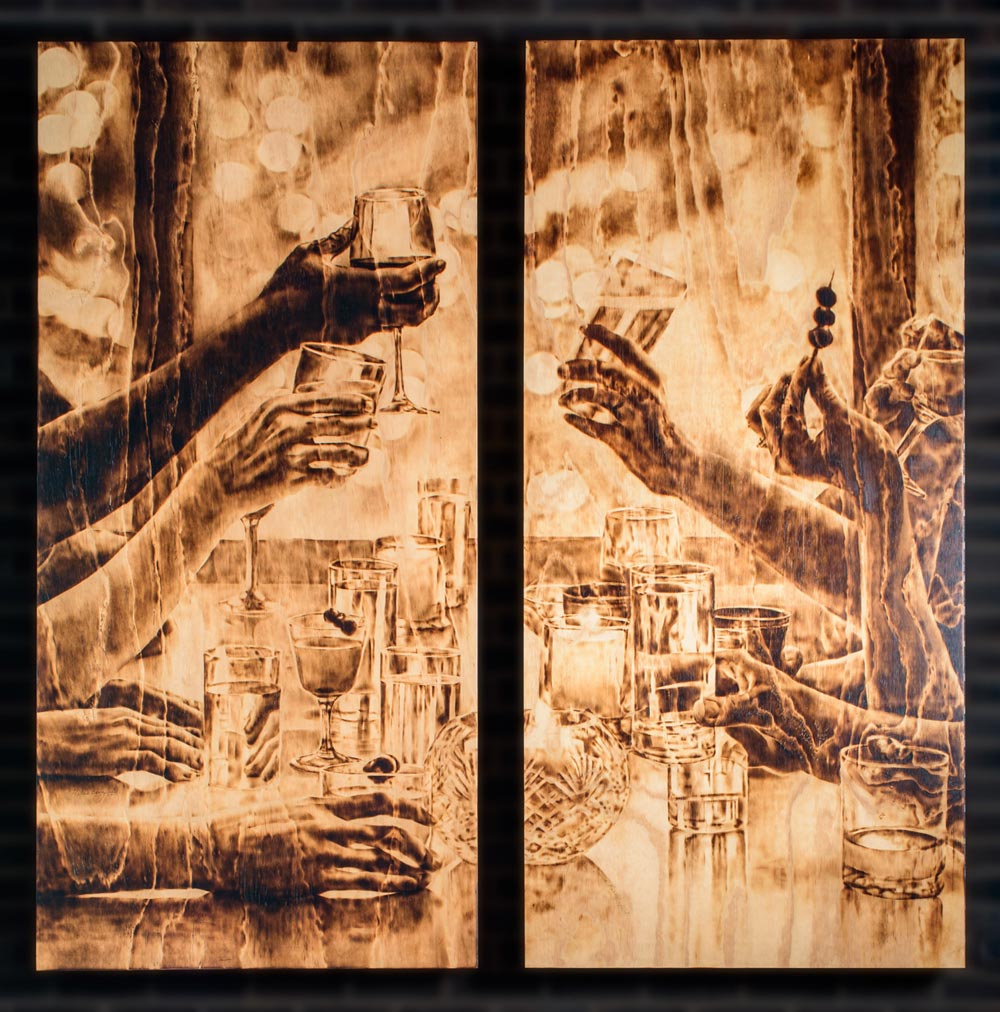 burned wood artwork of people holding up their glasses at a table