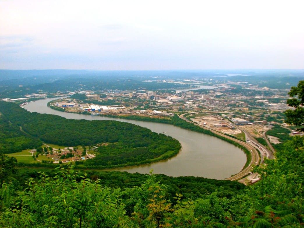 distant city surrounded by trees and a large river