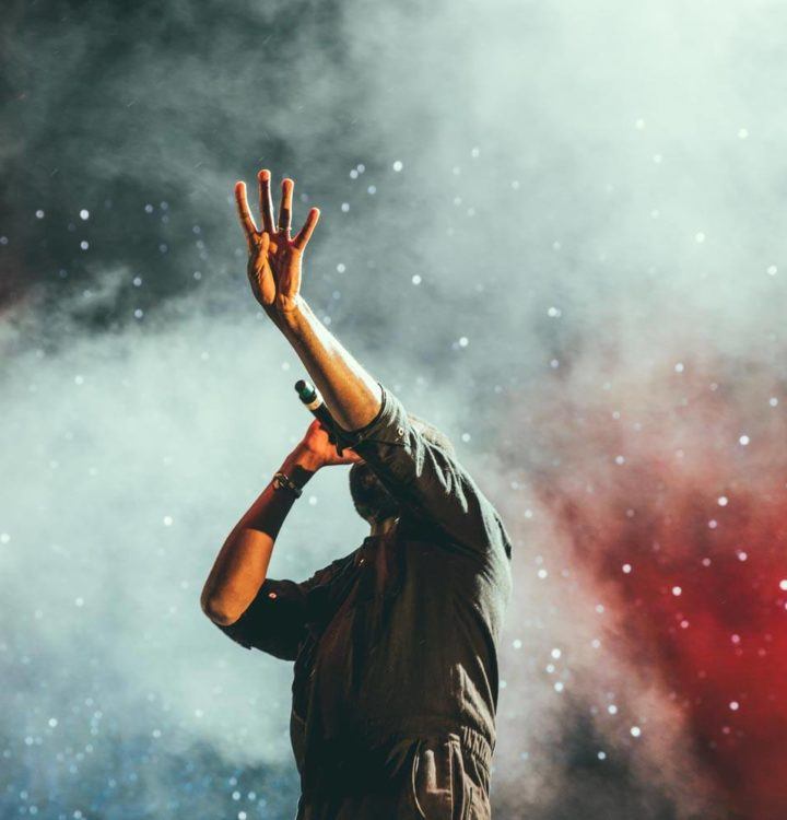 male singer performing to audience while on stage in theatre