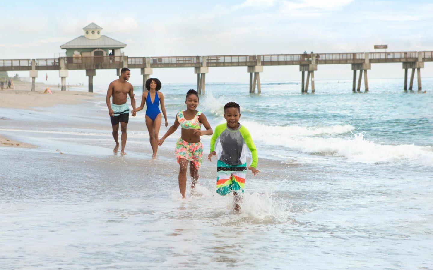 a happy family enjoying their time at a west palm beach near the boardwalk