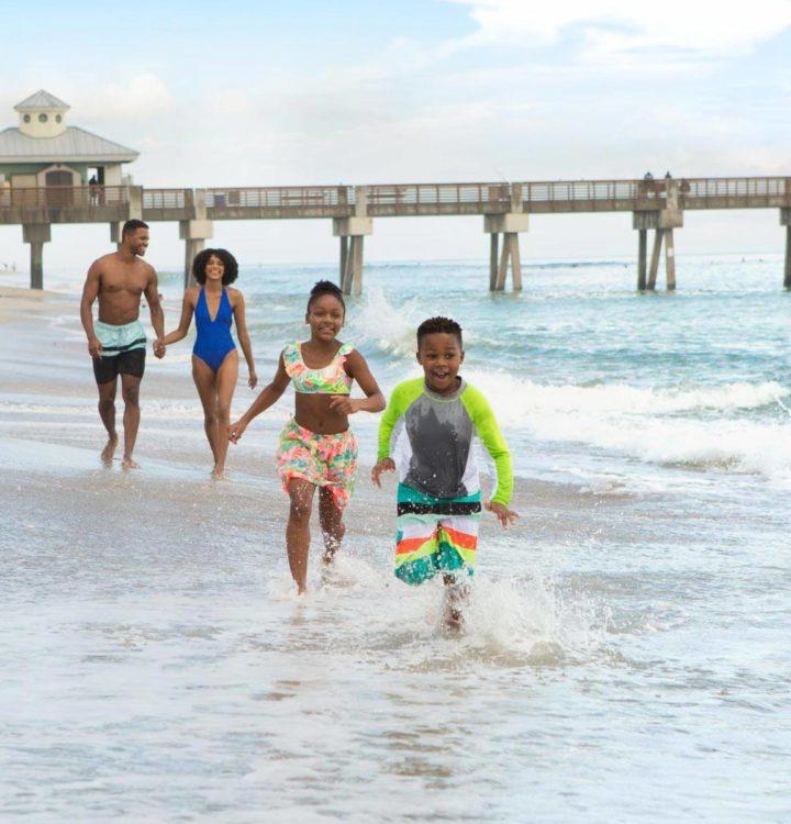 a happy family enjoying their time at a west palm beach near the boardwalk