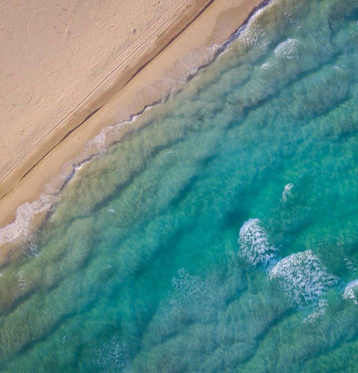 crystal clear waters slowly raising over the sandy beach