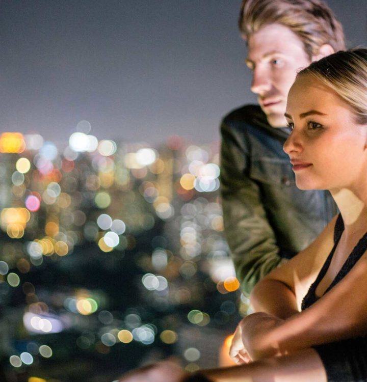 woman wearing black tank top looking at city lights