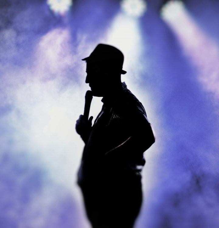 silhouette photo of man holding microphone