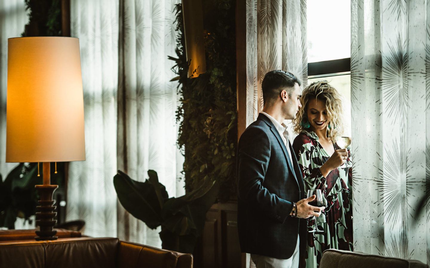 man in black suit jacket standing beside woman in black and white polka dot dress