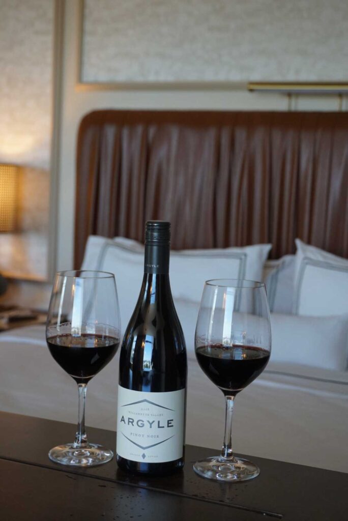 two wine bottles beside wine glass on table
