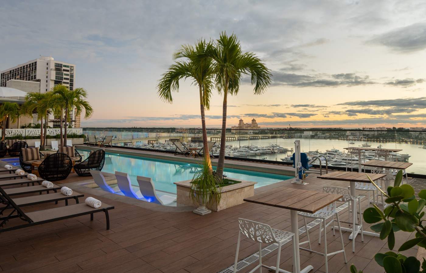 a large swimming pool with lounge chairs and palm trees