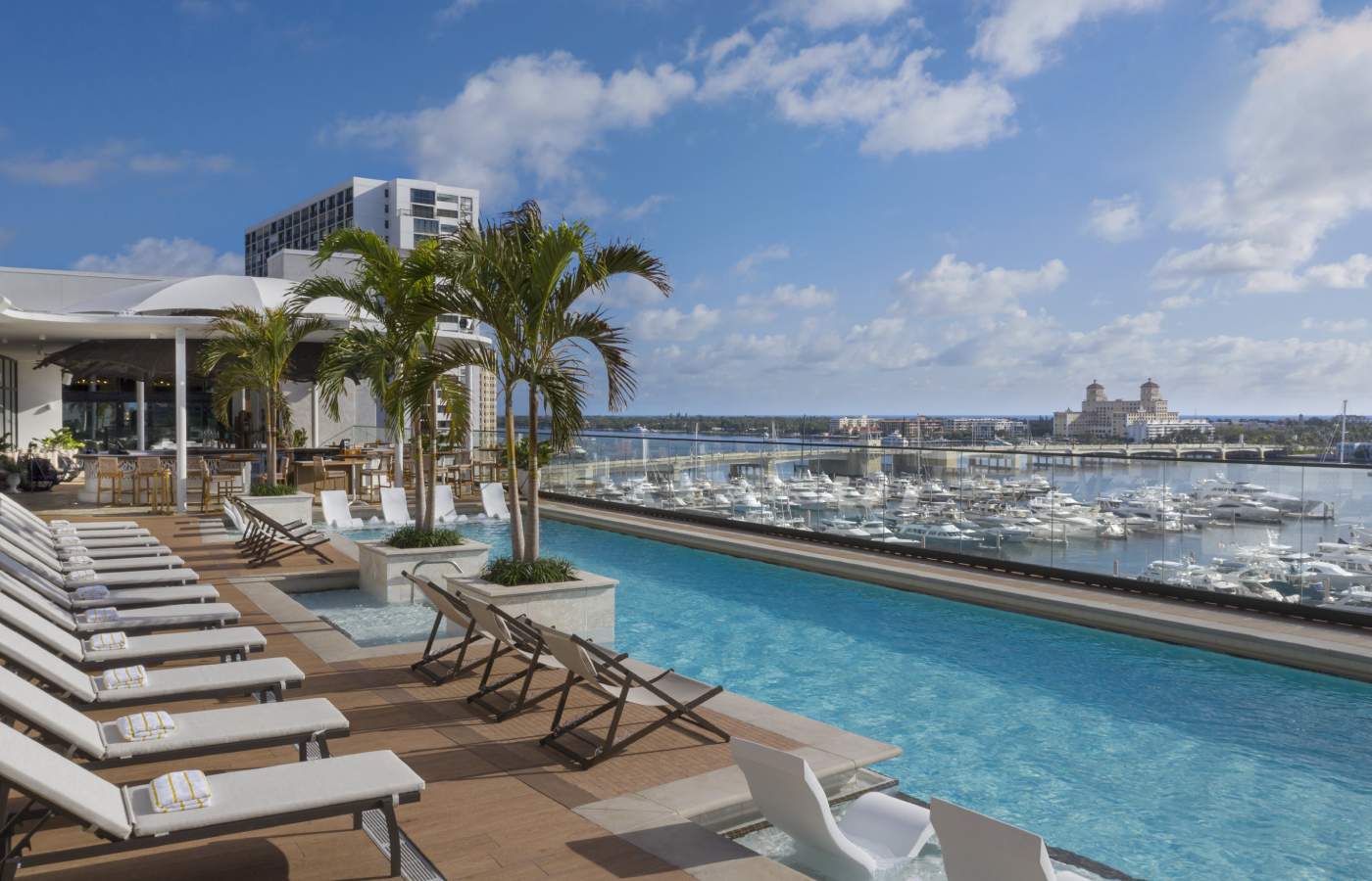 white and brown wooden chairs near swimming pool during daytime