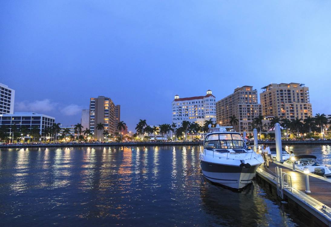 white and blue boat on water near city buildings during daytime