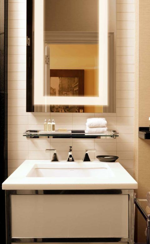 white ceramic sink and bright white towels in modern bathroom