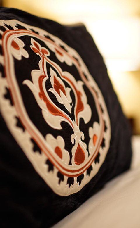 black, white, and red pillow on bed