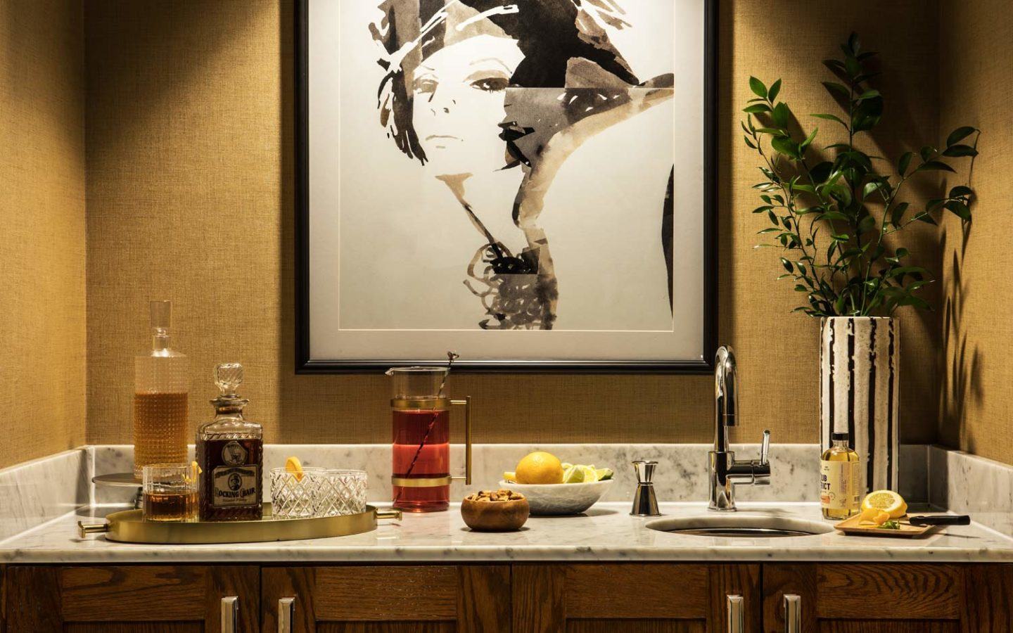 painting of woman's portrait on wall above mini bar