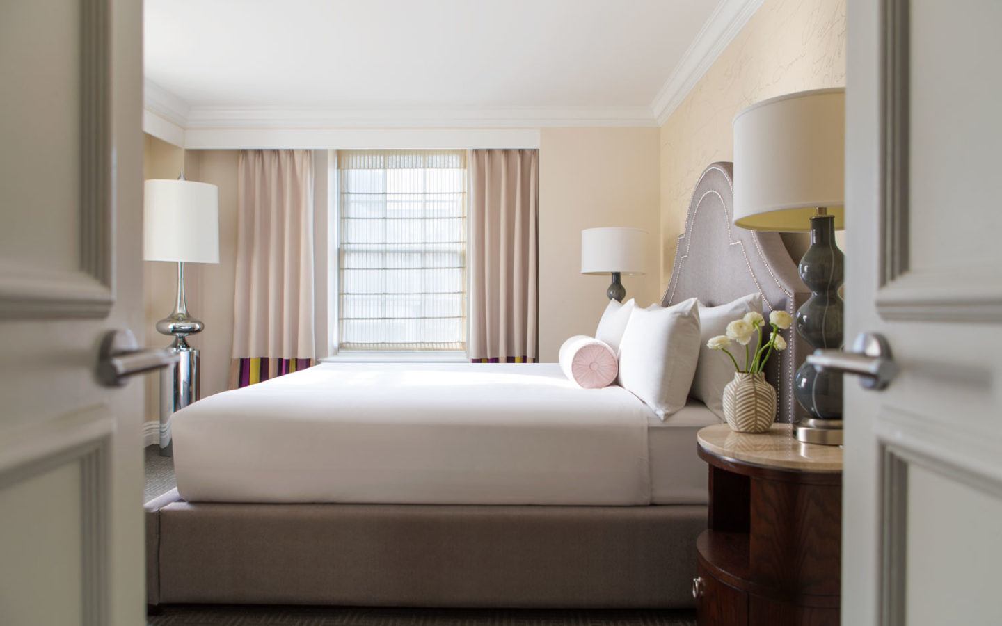 white mattress and brown bed frame next to large window