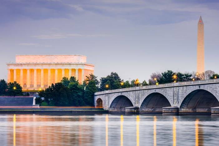a bridge over a body of water with a building in the background