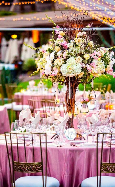 Tables are set with pink tablecloths and enchanting floral arrangements