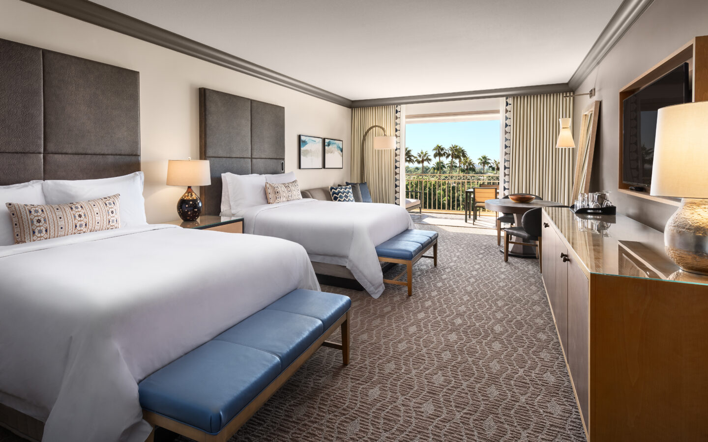 a hotel room with two beds and a balcony