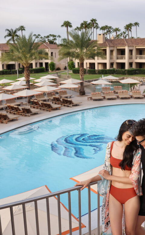 a man and a woman standing next to a pool