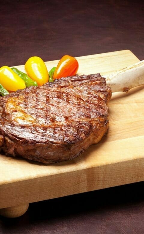 Tomahawk steak on wooden platter