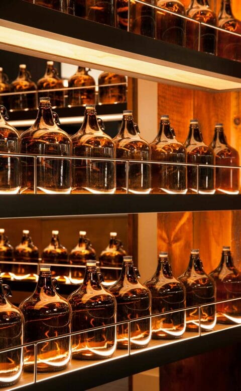 Shelves filled with glass beer growlers