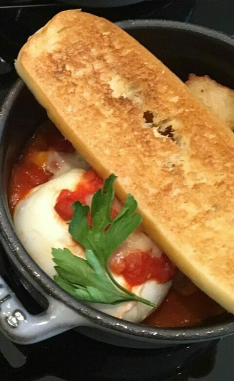 garlic bread over red pasta dish