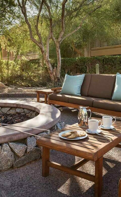firepit surrounded by wooden tables chairs and couches