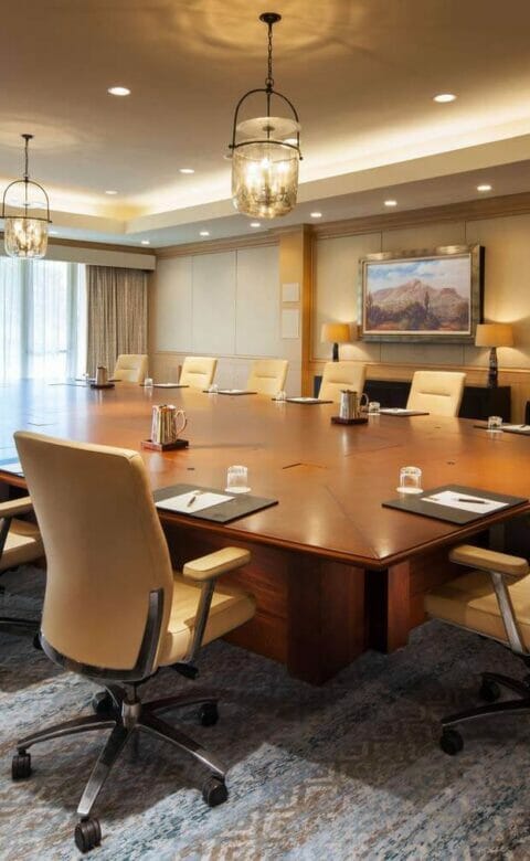 boardroom meeting space with large table surrounded by 15 chairs
