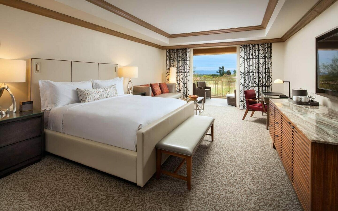 Canyon Suites guest bedroom with a king bed and doors opening to a balcony with seating