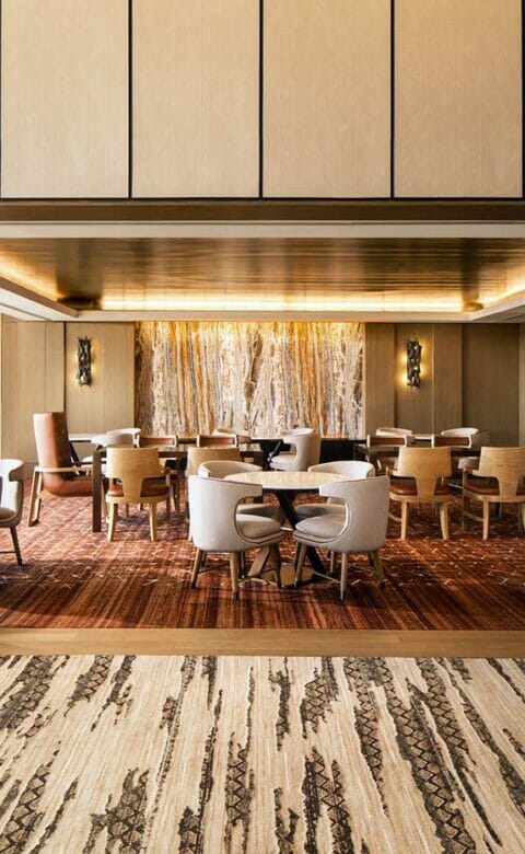 dining area entrance with two wooden abstract statues on each side and tables with chairs in the background