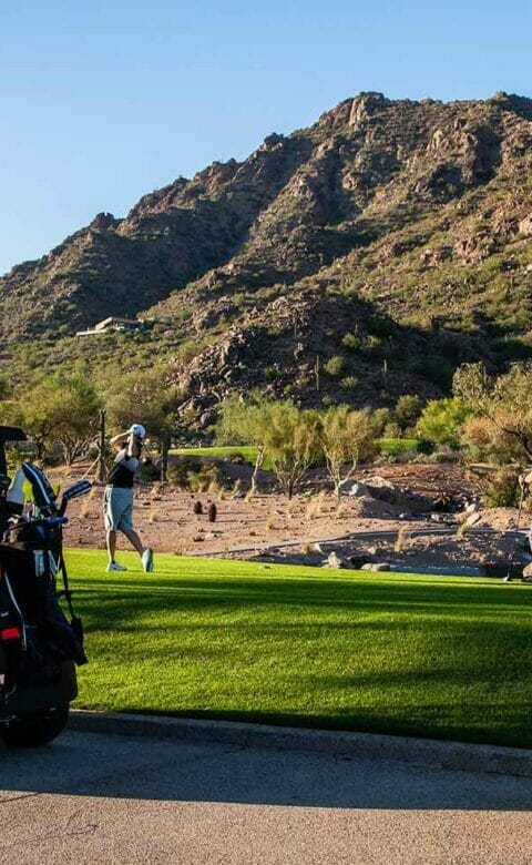 golf card with two golfers and mountain in the background