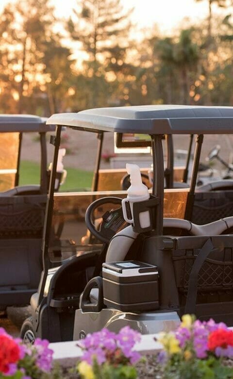 employee checking on one of five golf carts in a row
