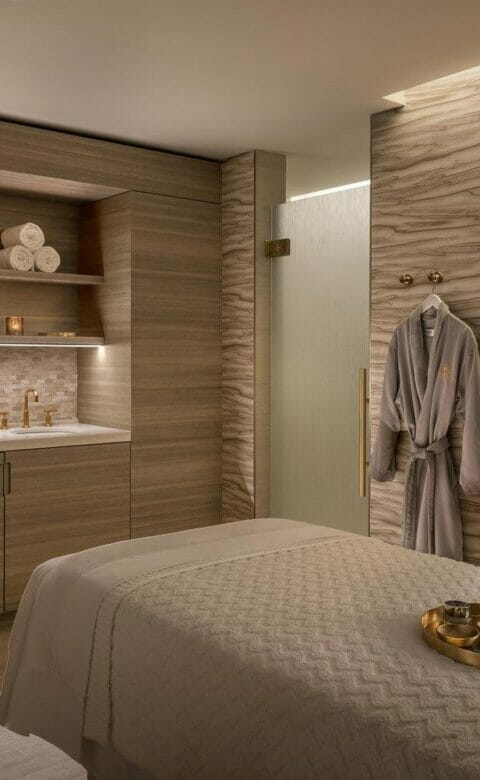 spa treatment room with long bed and robe hanging on wall