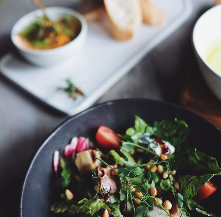closeup of salad and cooked meals on a wooden table